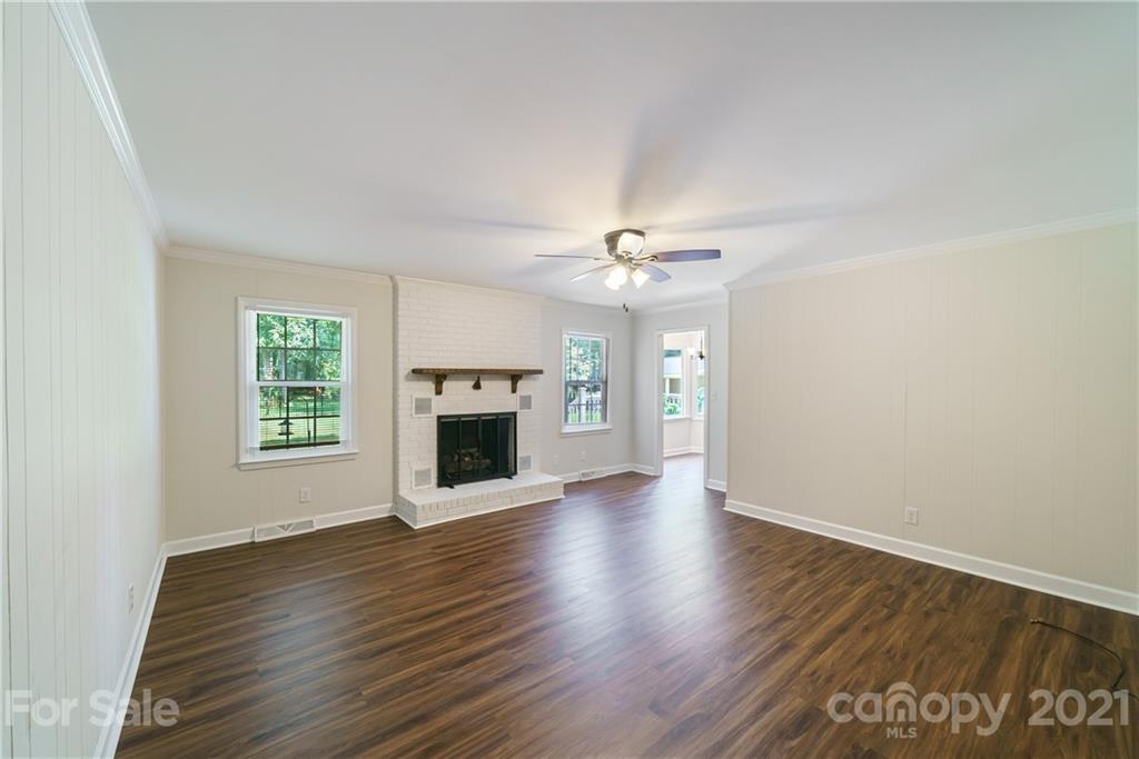 3340 Dan Hood Road Matthews, NC 28105 - Photo 9 of 48 an empty room with wooden floor fireplace and windows