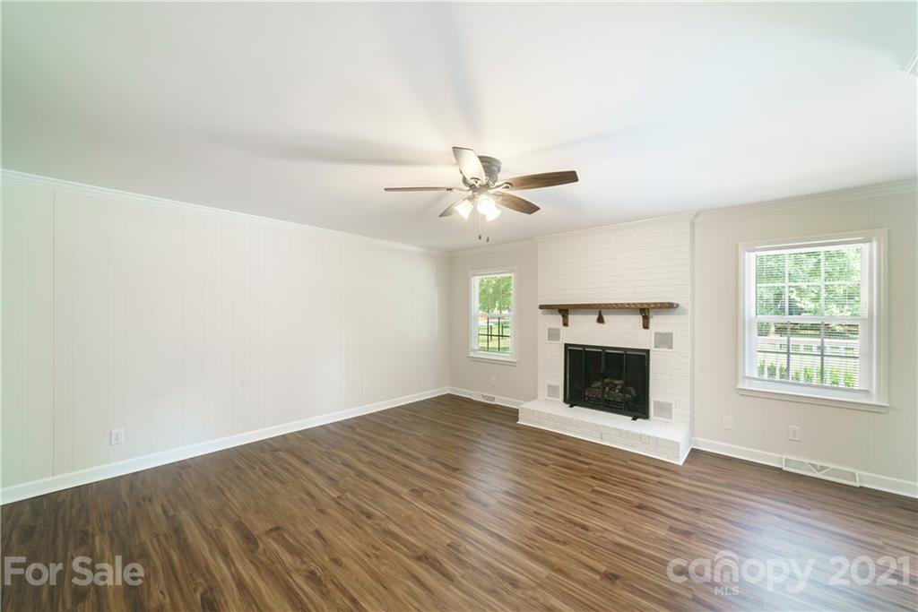 3340 Dan Hood Road Matthews, NC 28105 - Photo 10 of 48 an empty room with wooden floor fireplace and windows