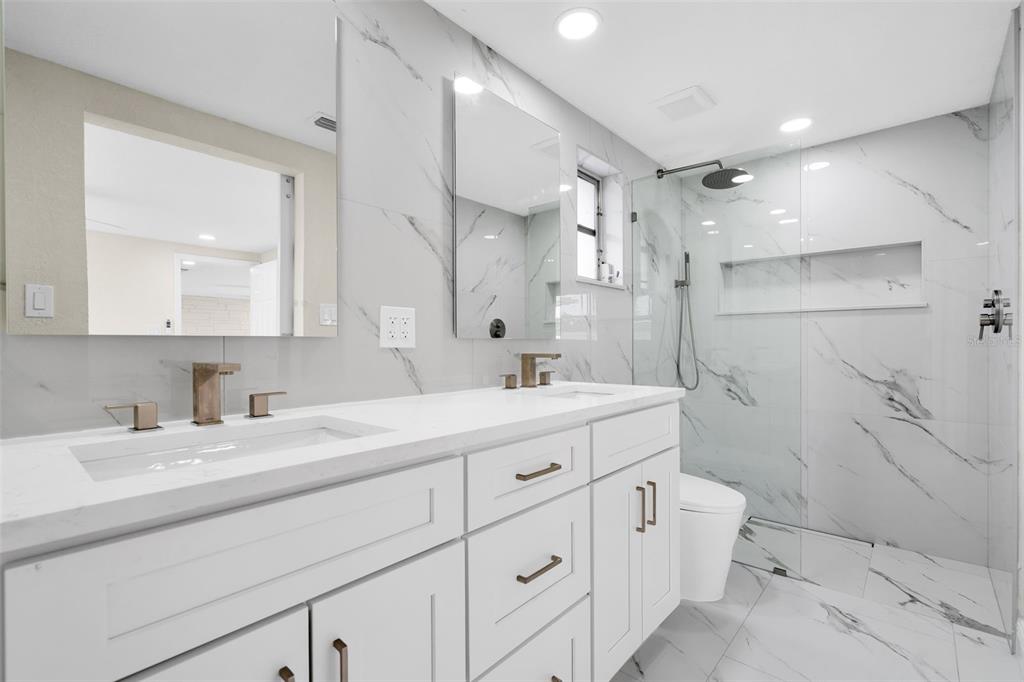5626 Moog Road Holiday, FL 34690 - Photo 19 of 38 a bathroom with a double vanity sink mirror double and shower