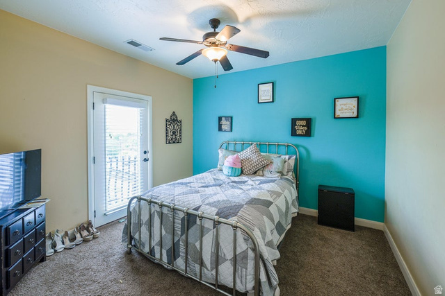 3683 South 2640 West St. George, UT 84790 - Photo 27 of 41 Bedroom featuring a ceiling fan, a private balcony access door with integrated blinds, and textured carpeting