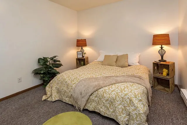 a bed sitting in a bedroom next to a lamp