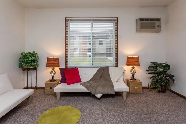 a living room with furniture and a potted plant