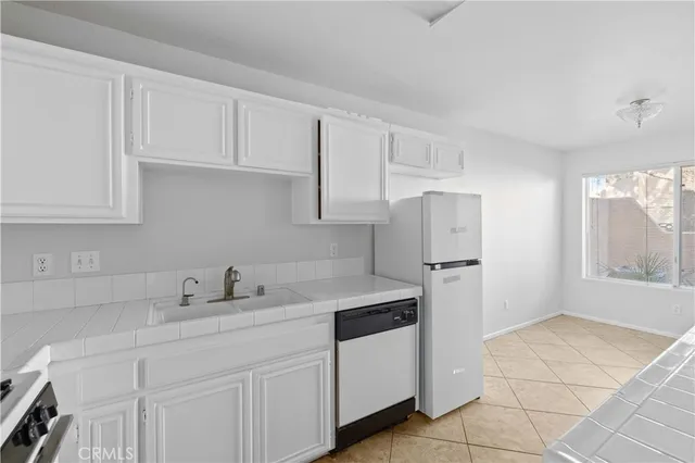 a kitchen with stainless steel appliances granite countertop a sink refrigerator and cabinets