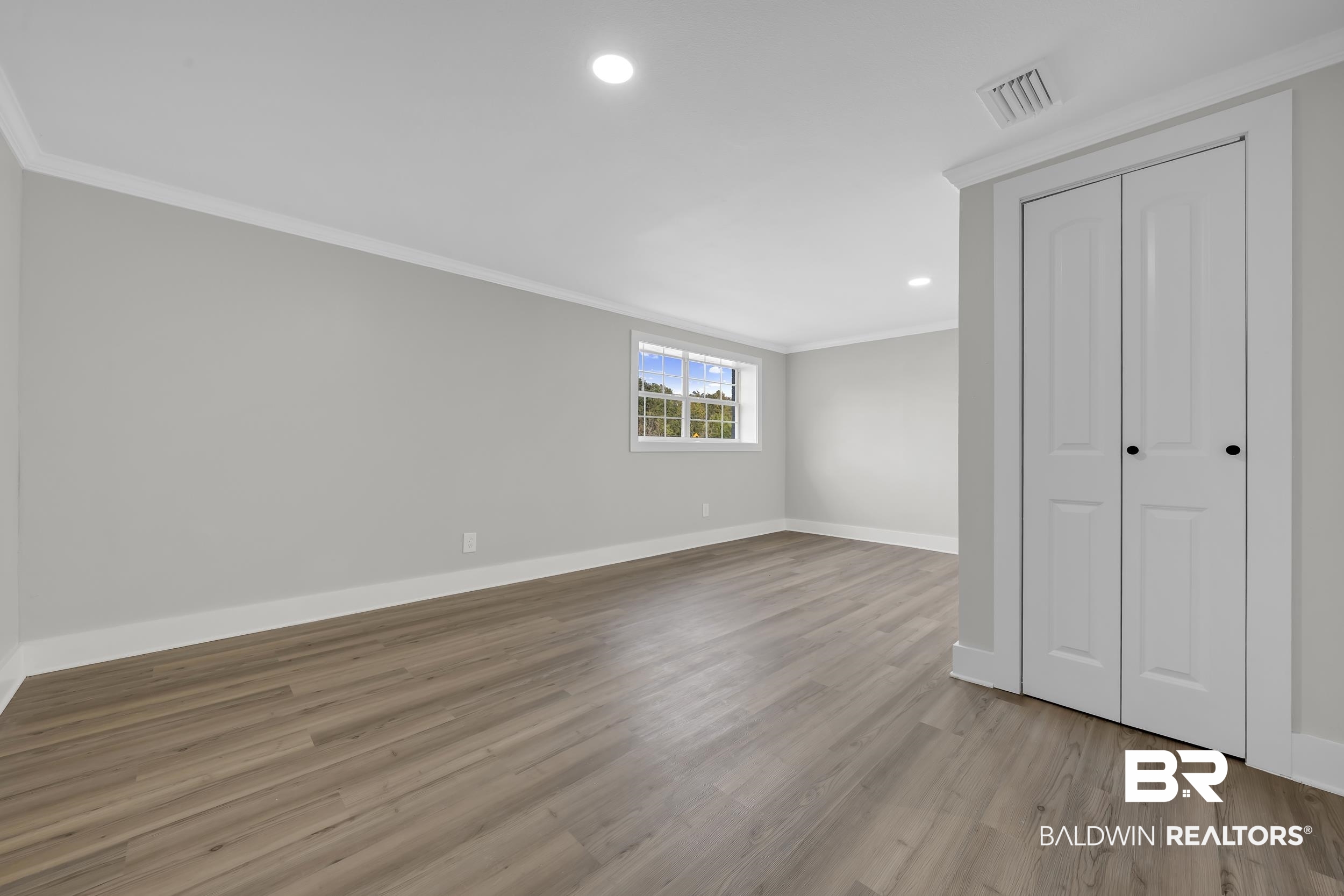 8351 Theodore Dawes Road Theodore, AL 36582 - Photo 24 of 46 Unfurnished bedroom featuring recessed lighting, crown molding, a closet, and light wood-style flooring