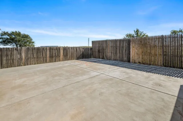 a view of backyard with wooden fence
