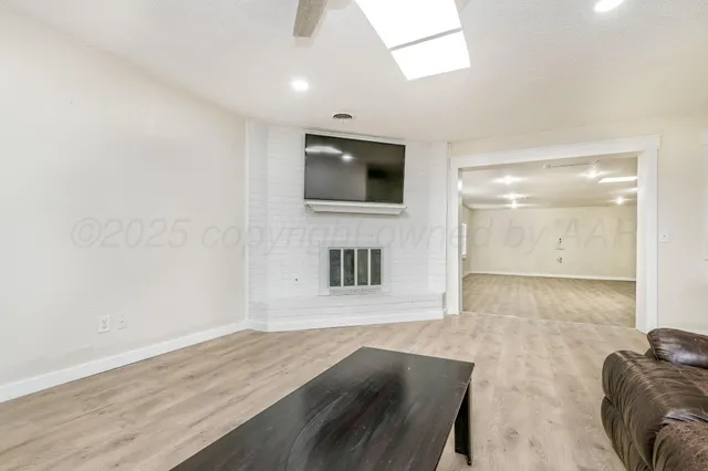 a view of an empty room with a fireplace and a window