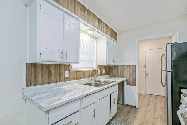 a kitchen with a sink refrigerator and cabinets