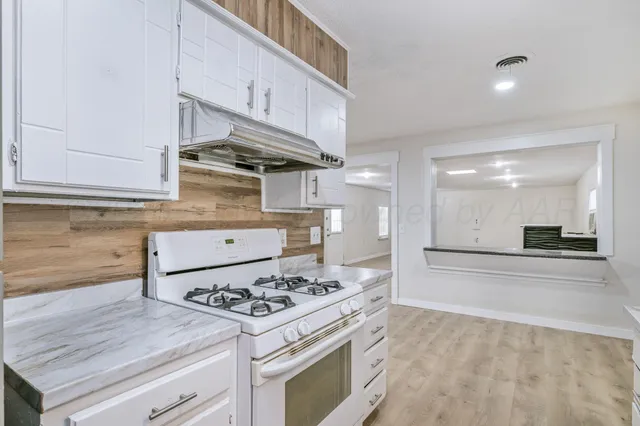 a kitchen with stainless steel appliances granite countertop a stove and a cabinets