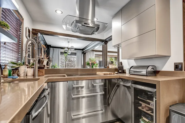 a metallic refrigerator freezer and a stove sitting inside of a kitchen