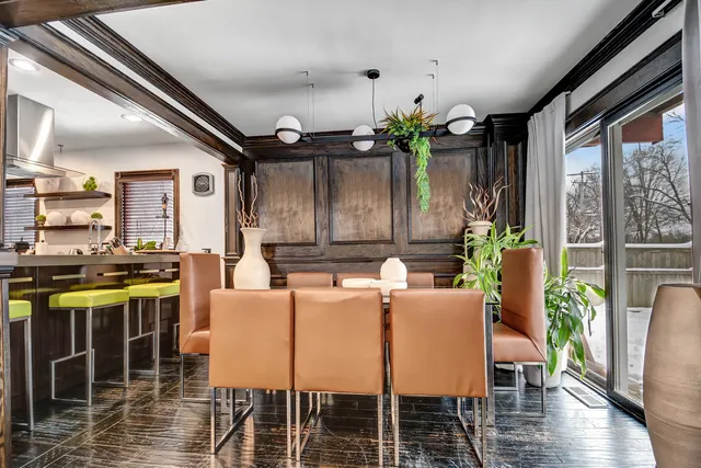 a dining room with furniture potted plants and wooden floor