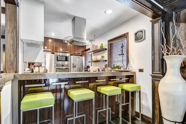 a kitchen with stainless steel appliances granite countertop a sink a stove and a refrigerator