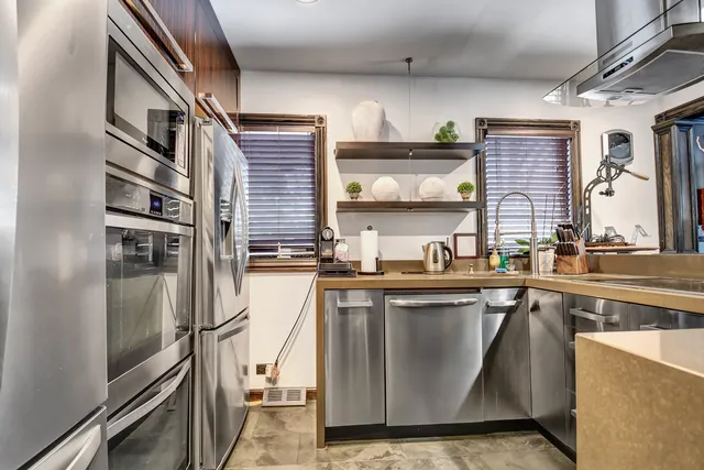 a kitchen with stainless steel appliances granite countertop a sink and a stove