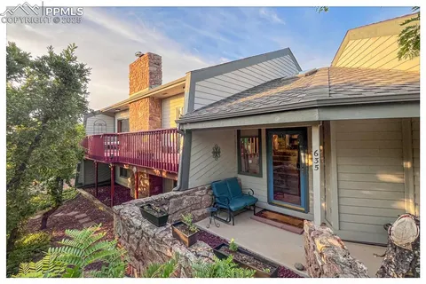 a view of a house with a patio and wooden fence