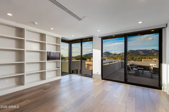 a living room with stainless steel appliances wooden floor and large window