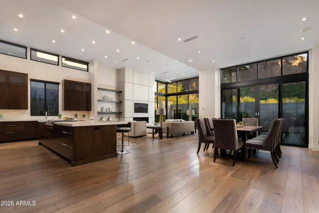 a living room with couches and kitchen view with wooden floor