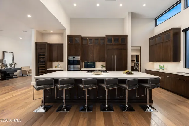 a kitchen with a table chairs sink and wooden floor