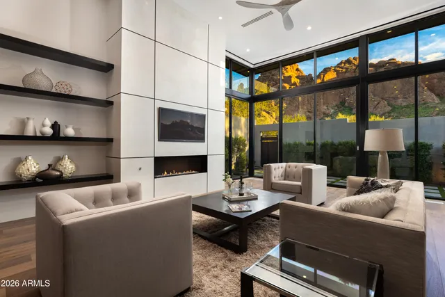 a living room with furniture a flat screen tv and a large window