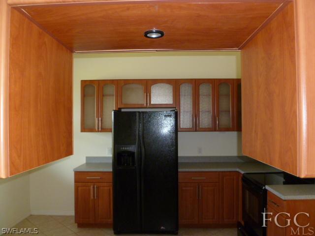 2514 23rd Street Southwest Lehigh Acres, FL 33976 - Photo 12 of 16 a kitchen with a refrigerator and cabinets