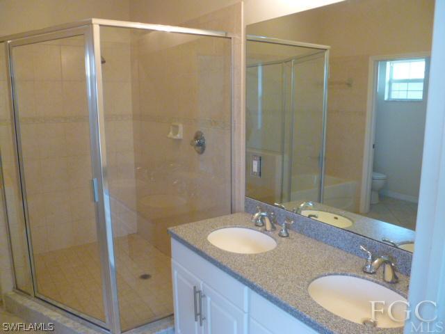 2514 23rd Street Southwest Lehigh Acres, FL 33976 - Photo 13 of 16 a bathroom with a granite countertop sink shower and a mirror