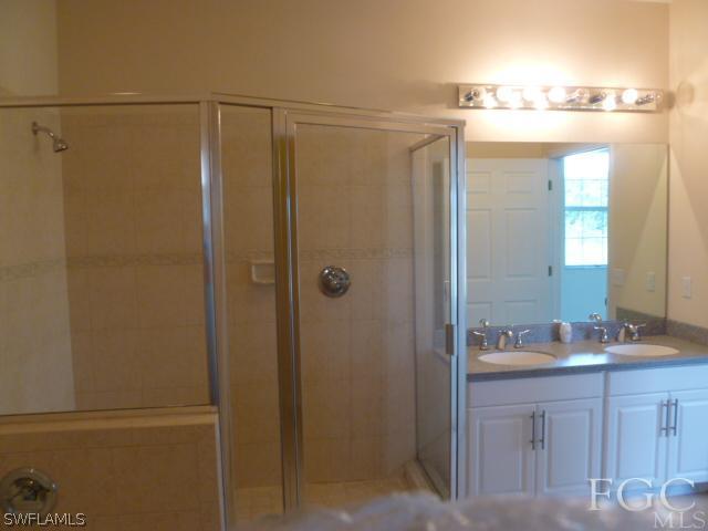 2514 23rd Street Southwest Lehigh Acres, FL 33976 - Photo 15 of 16 a bathroom with a shower sink vanity and mirror