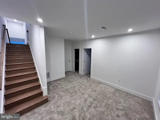 a view of an empty room with wooden stairs