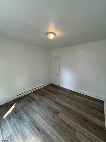 a view of an empty room and wooden floor