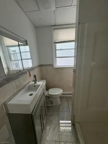 a bathroom with a sink a toilet and a mirror
