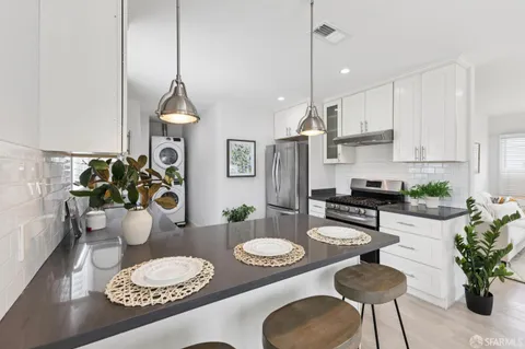 a kitchen with stainless steel appliances a dining table and chairs