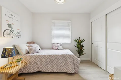 a bedroom with a bed and a potted plant