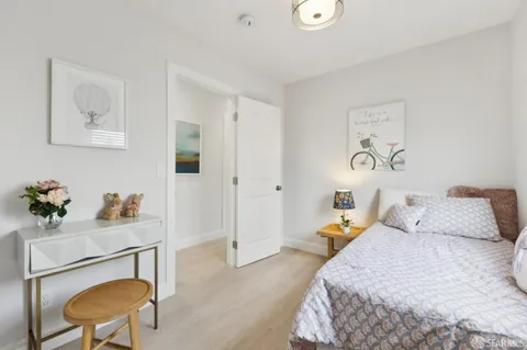 a bedroom with a bed a couch and a potted plant