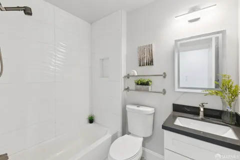 a white toilet sitting next to a white tub