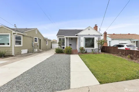 a front view of a house with a garden and plants