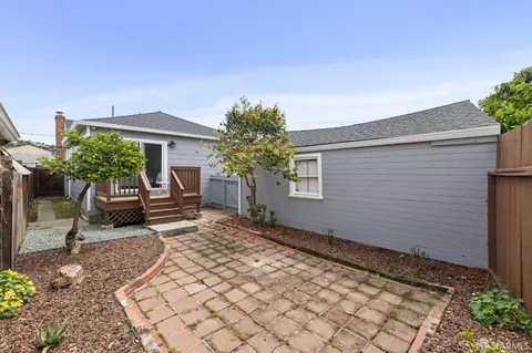 a view of a house with backyard and sitting area