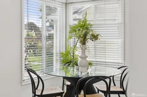 a dining room with furniture and potted plants