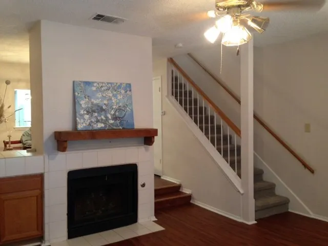 a living room with wooden floor a fireplace and a chandelier