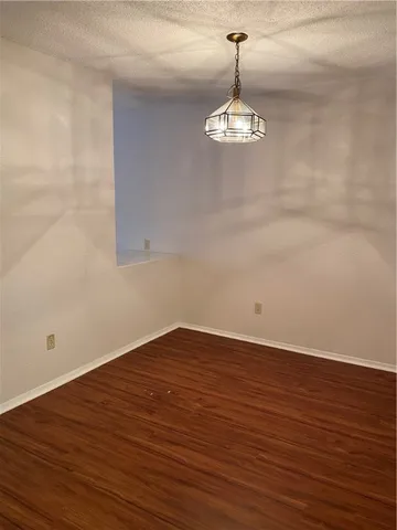 a view of empty room with wooden floor and ceiling fan