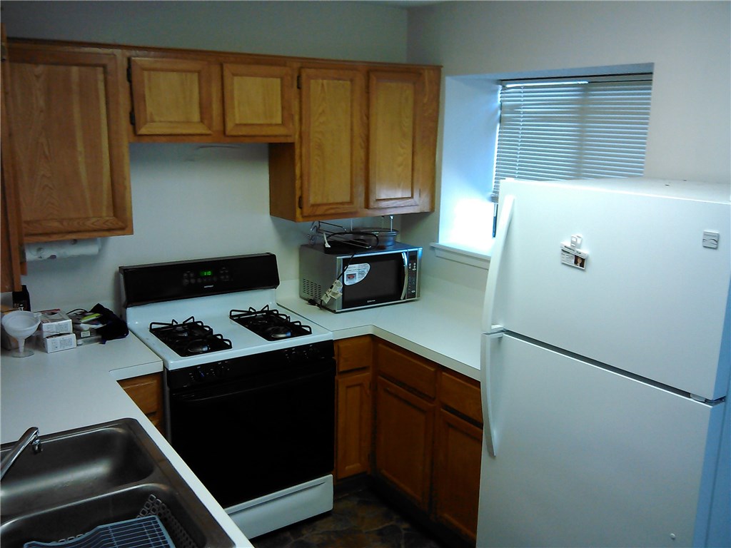 11821 Bittern Hollow, Unit 20 Austin, TX 78758 - Photo 6 of 14 a kitchen with stainless steel appliances granite countertop a refrigerator and a stove