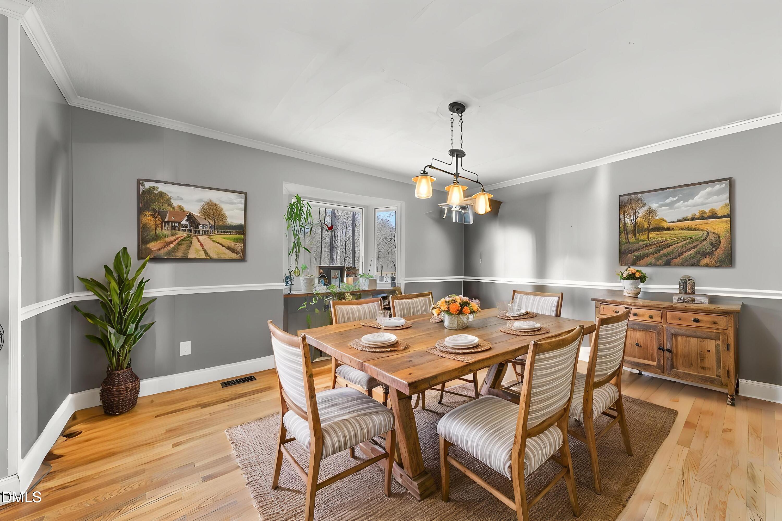 4739 Wild Azalea Place Rougemont, NC 27572 - Photo 15 of 48 a view of a dining room with furniture wooden floor and chandelier
