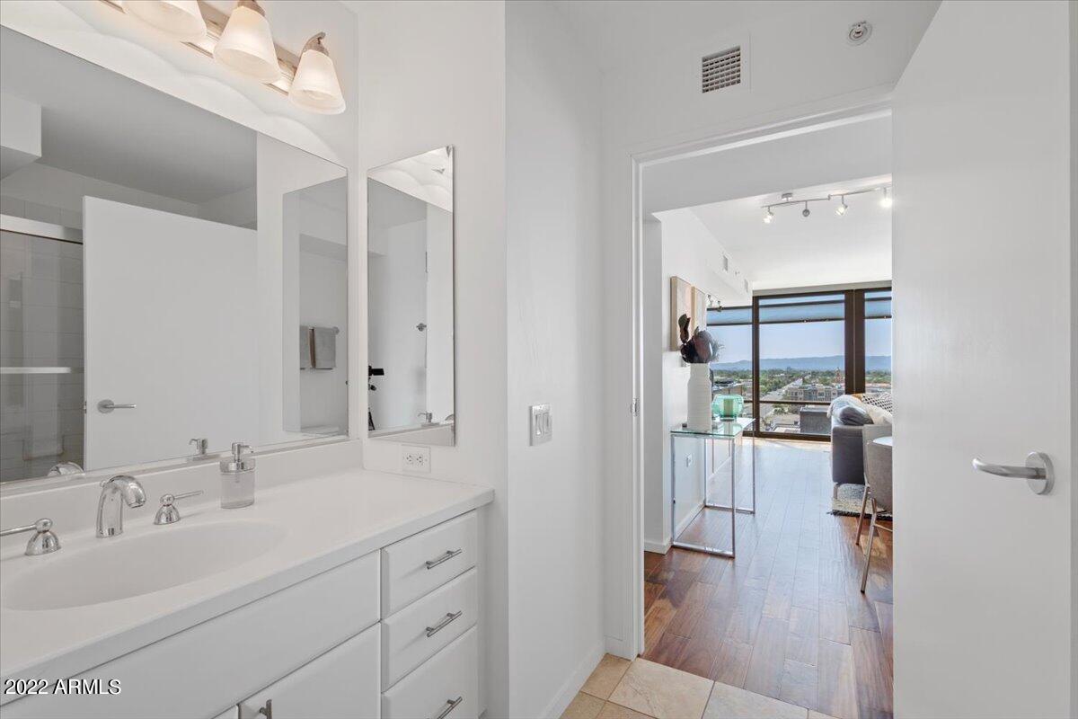 4808 North 24th Street, Unit 1007 Phoenix, AZ 85016 - Photo 16 of 19 a en suite bathroom with a double vanity sink a mirror and shower