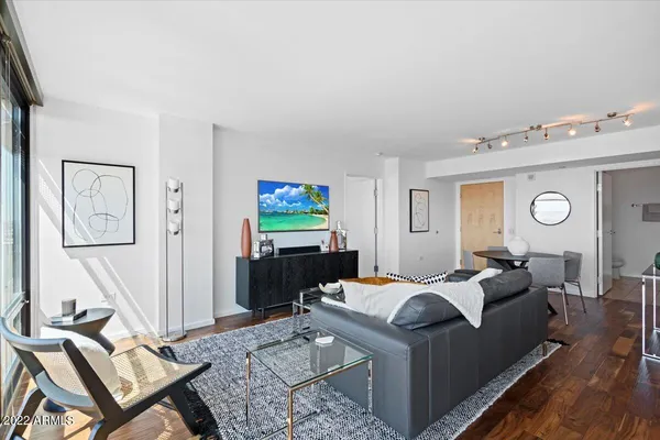 a living room with furniture a flat screen tv and a table