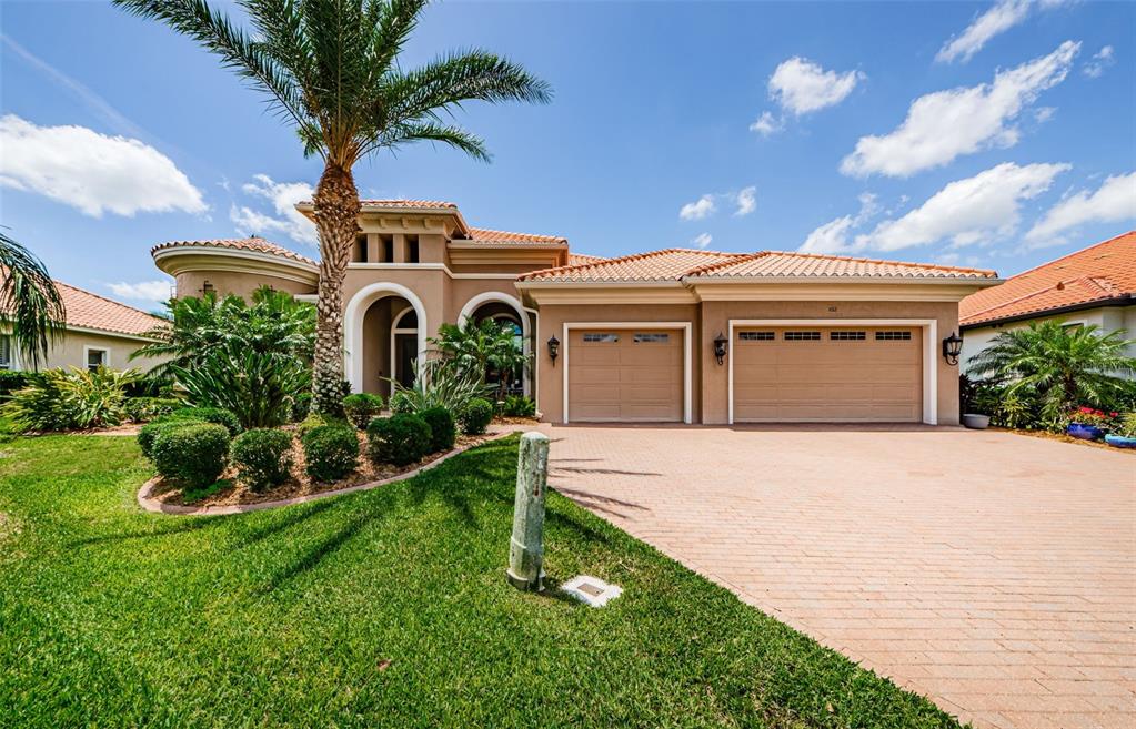 a front view of a house with a garden and plants