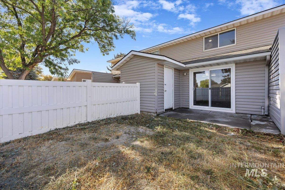 259 Pheasant Road, Unit 83 Twin Falls, ID 83301 - Photo 21 of 26 Rear exterior featuring vinyl siding, an outdoor patio, sliding glass door, and white privacy fencing