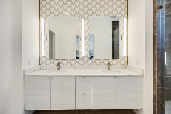 a bathroom with a double vanity sink mirror and shower