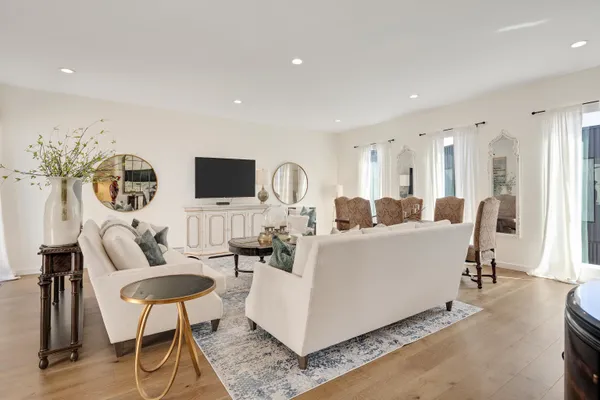a living room with furniture a flat screen tv and kitchen view
