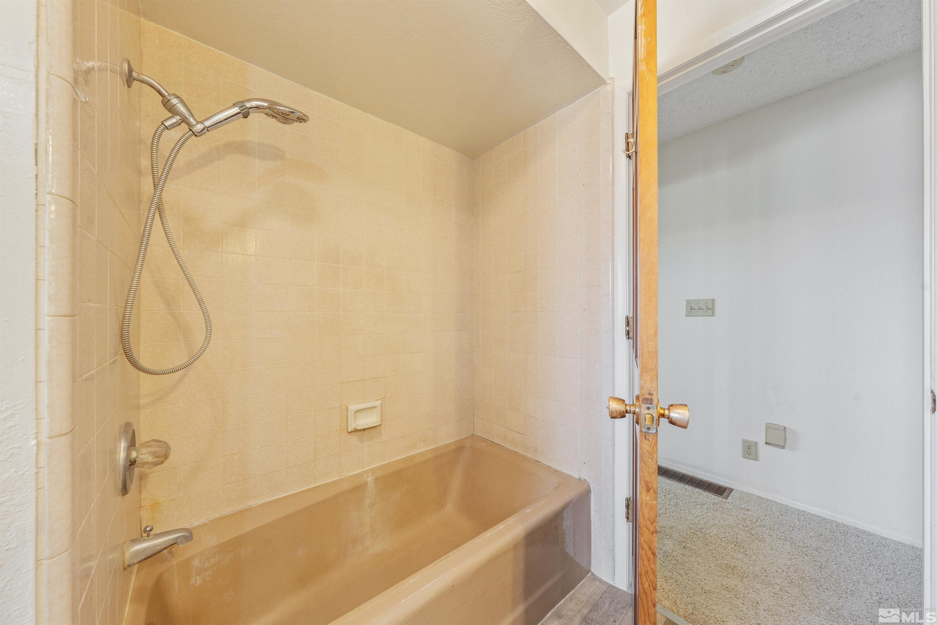 9320 Arrowhead Way Reno, NV 89506 - Photo 22 of 39 a bathroom with a shower and a bath tub