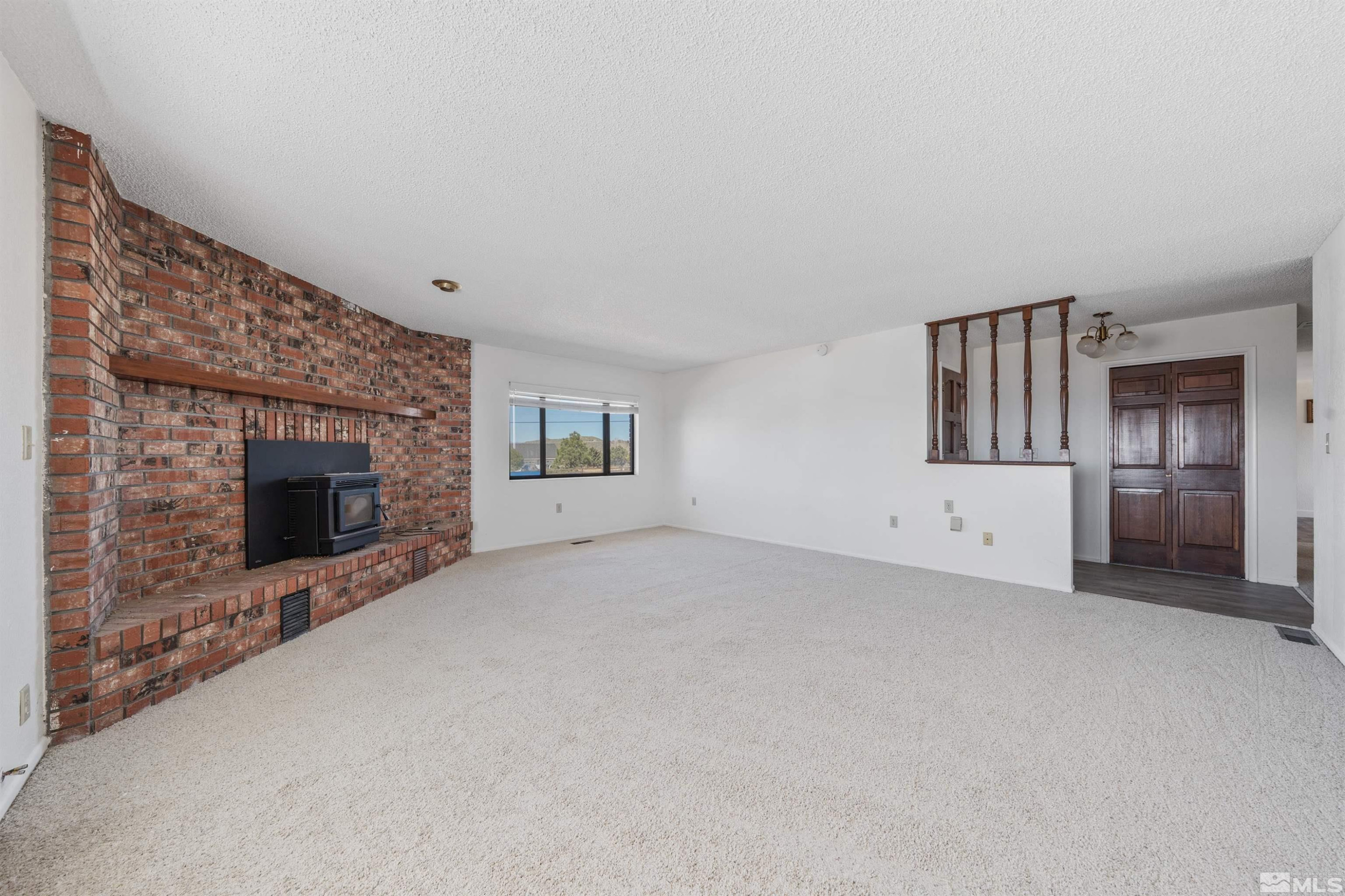 9320 Arrowhead Way Reno, NV 89506 - Photo 6 of 39 a view of an empty room with a fireplace and a window