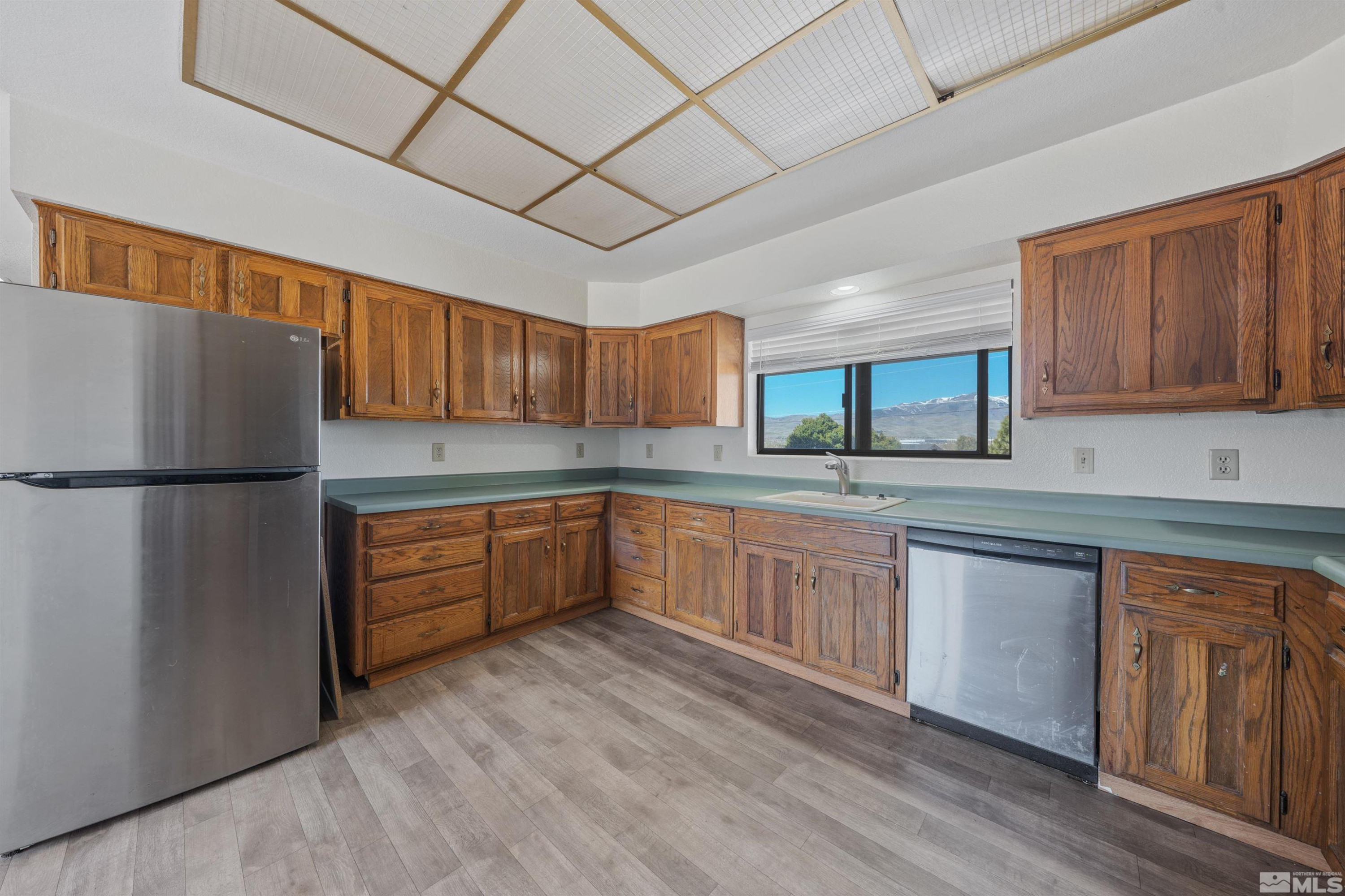9320 Arrowhead Way Reno, NV 89506 - Photo 8 of 39 a kitchen with stainless steel appliances granite countertop a refrigerator a sink dishwasher a stove with wooden cabinets and floors