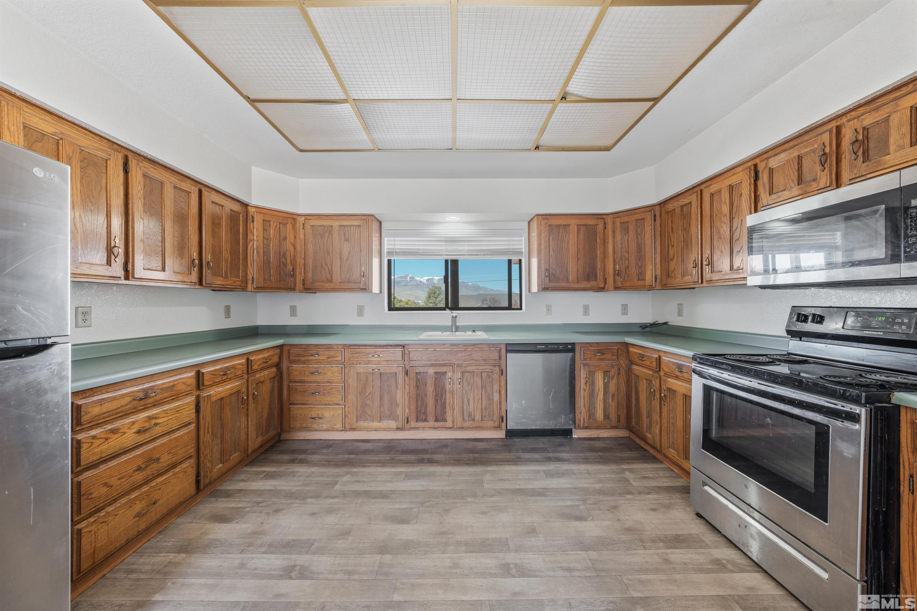 9320 Arrowhead Way Reno, NV 89506 - Photo 10 of 39 a kitchen with granite countertop wooden cabinets stainless steel appliances and a counter space