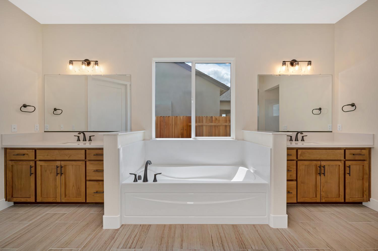 3922 Buxus Road Rocklin, CA 95765 - Photo 7 of 11 a spacious bathroom with a tub double vanity sink and a mirror
