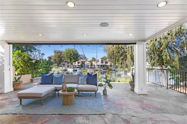 a living room with patio furniture and a potted plant